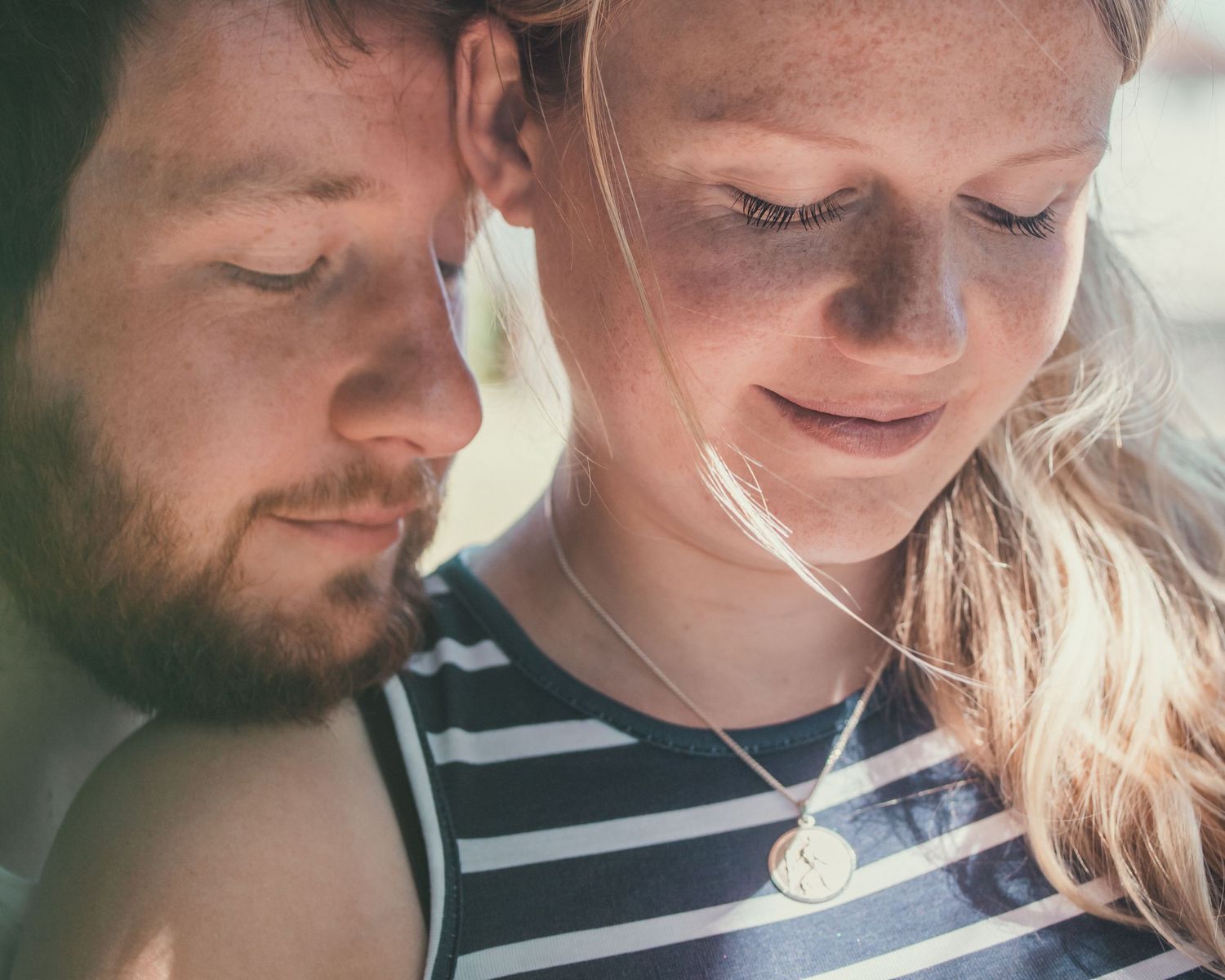 close up of man and woman smiling at baby bump