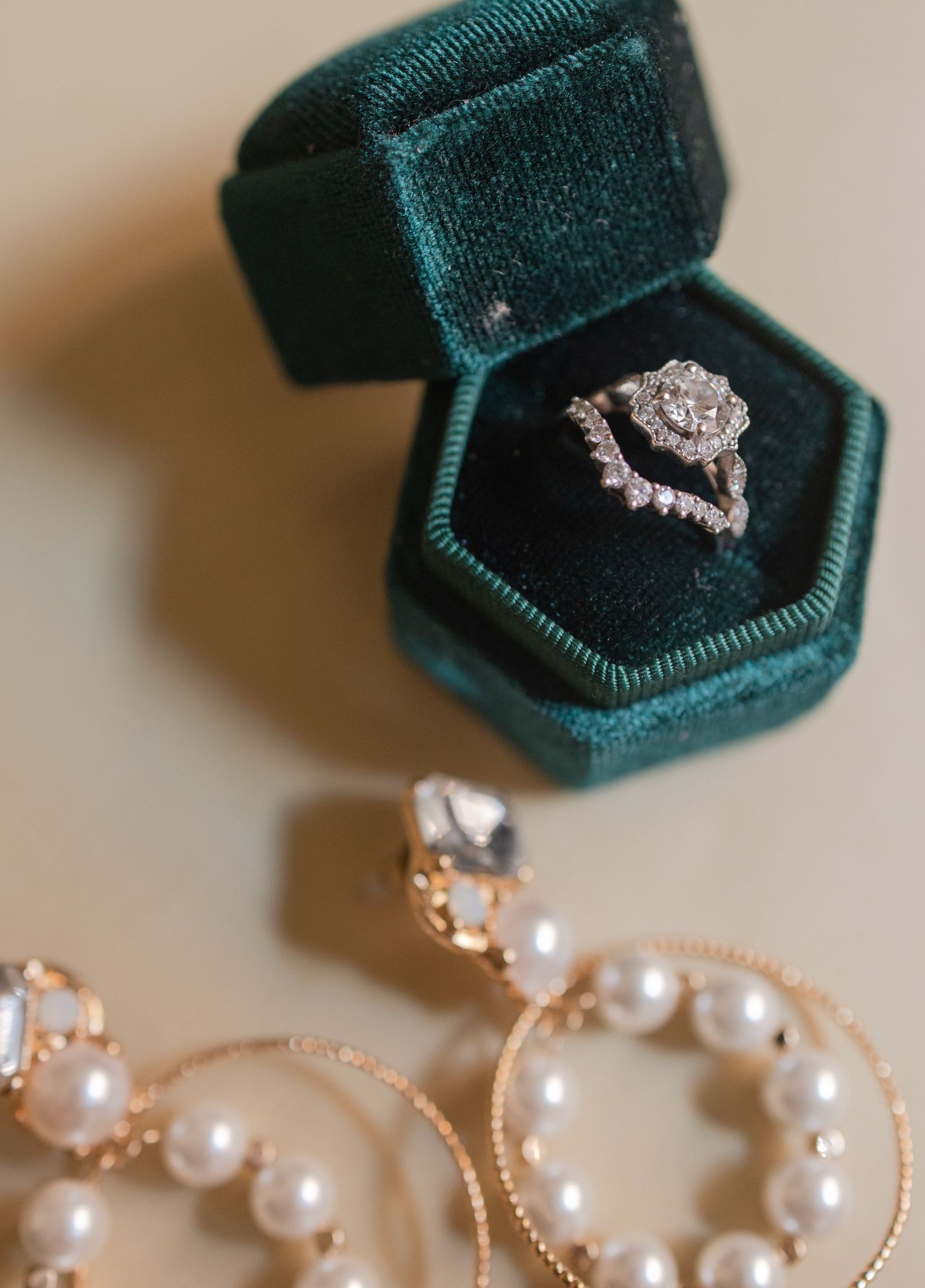 Engagement ring and wedding band with earrings detail shot