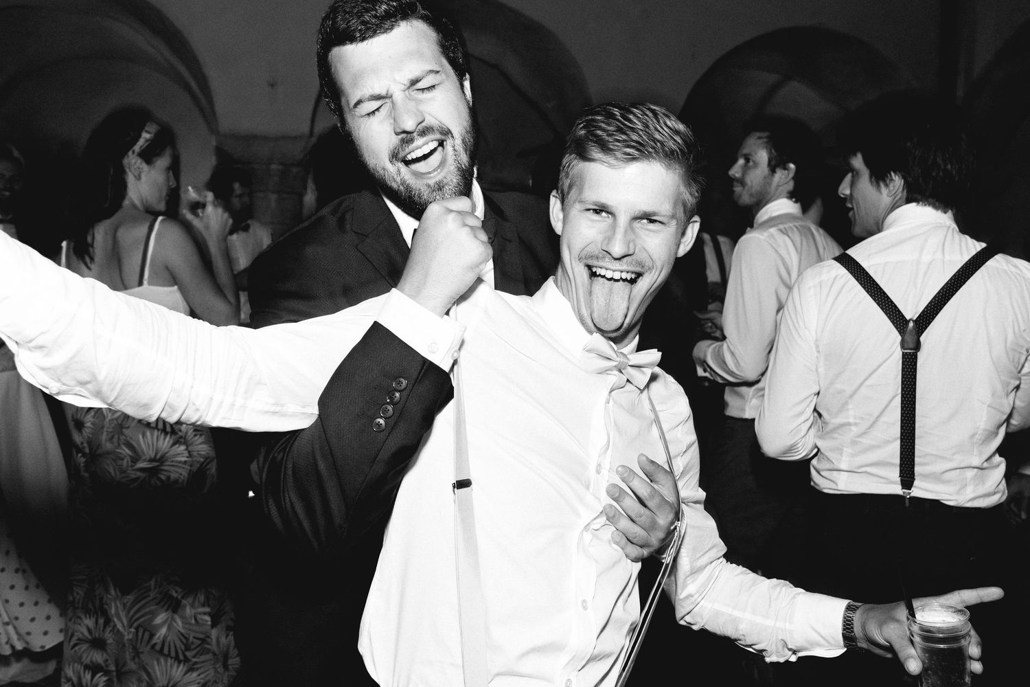 Black and white photo of guests enjoying themselves at a formal celebration party.