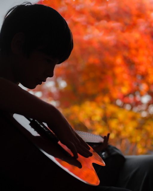 Young boy silhouette playing guitar In home lifestyle family portrait photography session, North Vancouver photographer