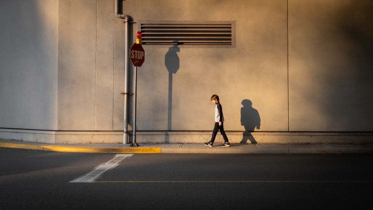 silhouette of young child walking on urban street at dusk, street photography, outdoor lifestyle north Vancouver photographer