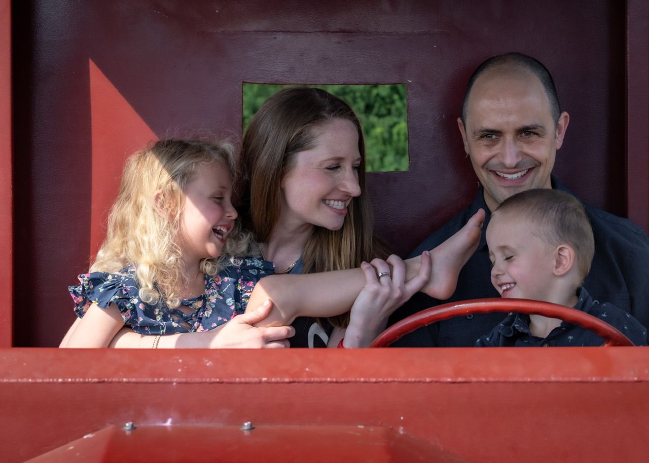 laughing family of four at their photo session at Shipyards in North Vancouver