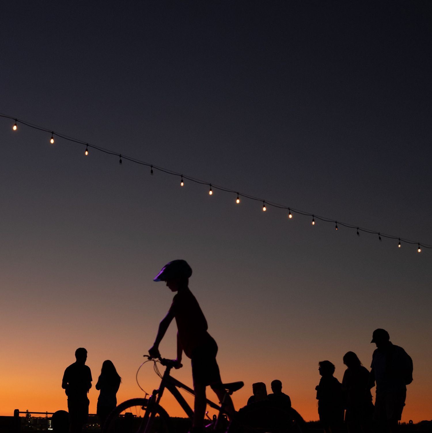 Family silhouettes on bicycle at sunset, The Shipyards Lomsdale North Vancouver family lifestyle photographer
