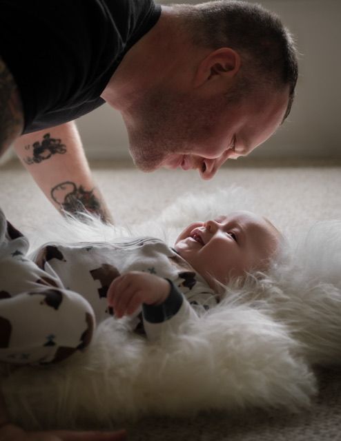 Dad with tattooed arm holding newborn baby, family portrait session, North Vancouver photographer