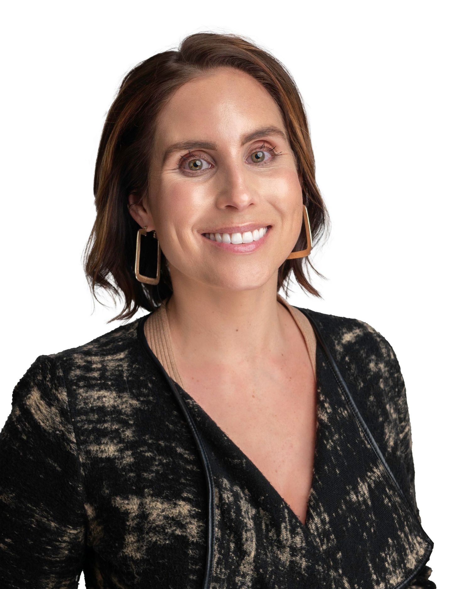 Professional portrait with person wearing black and tan patterned top and gold earrings.