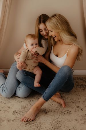 Candid moment between parent and child sitting on floor during studio session.