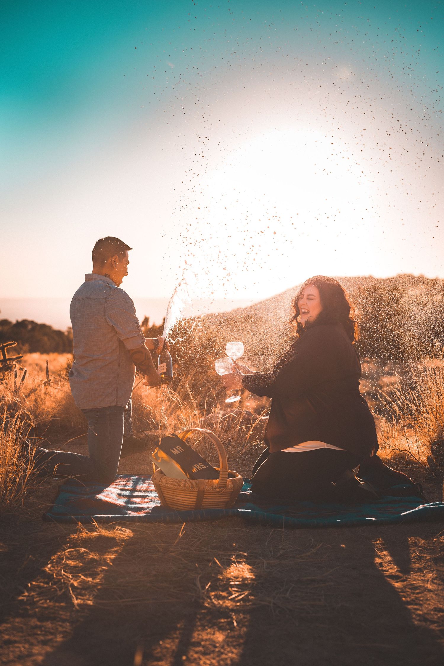 Couple celebrating their engagement spraying champaigne