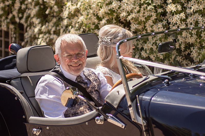 father of the bride and bride in antique car