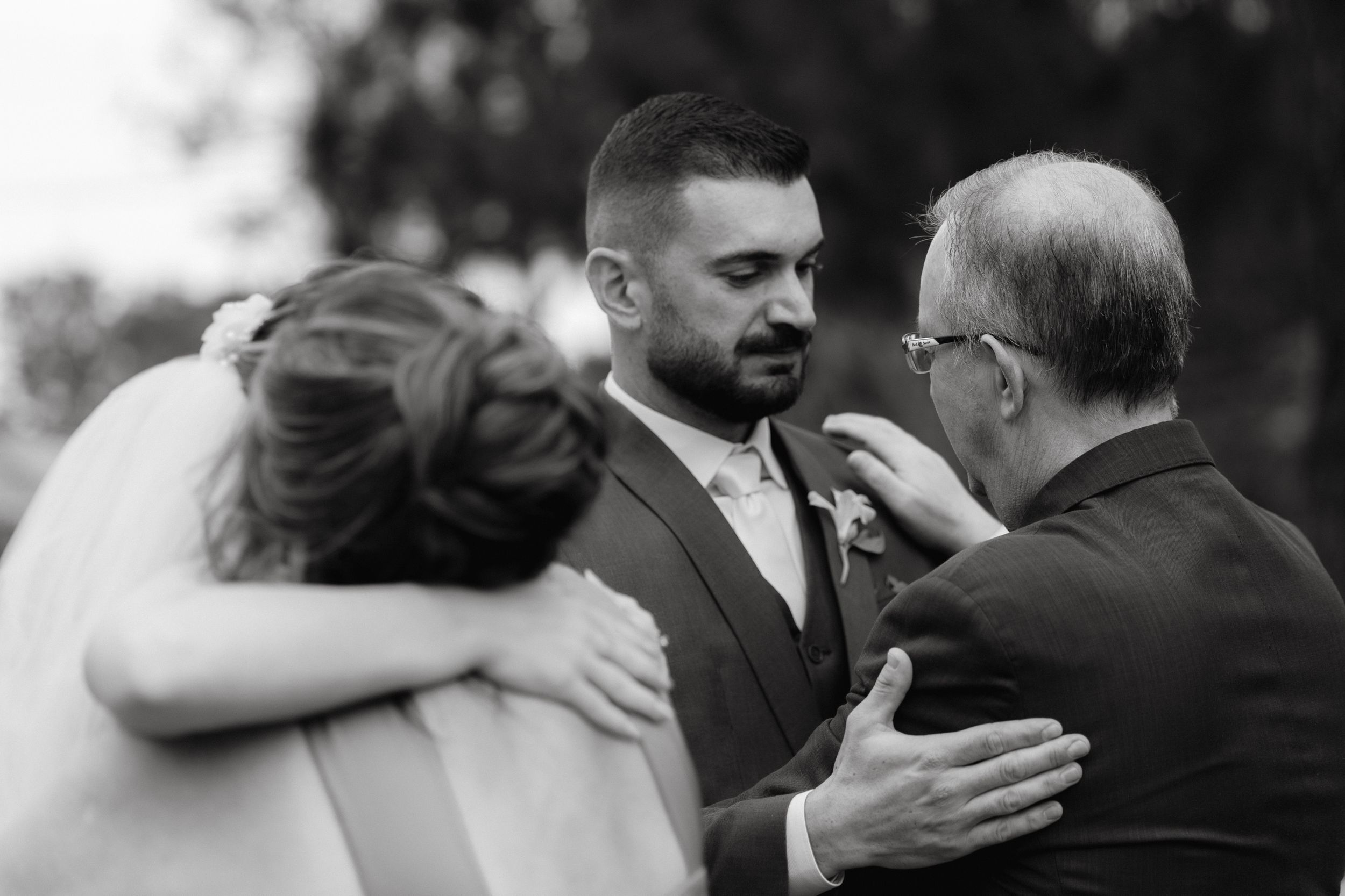 An emotional embrace during the wedding ceremony with guests looking on.