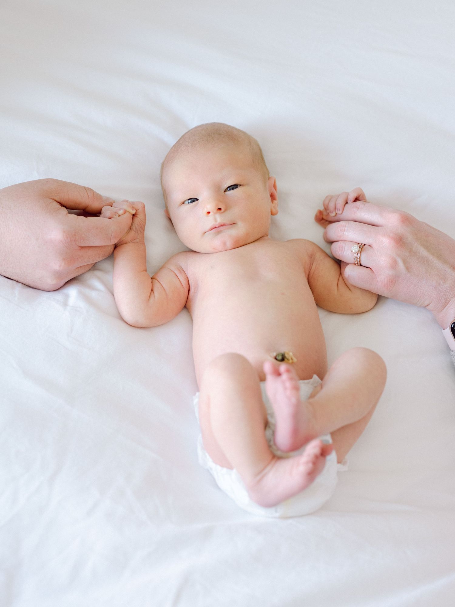 newborn baby boy holding hands with his mom and dad in Layton, Utah Davis County.