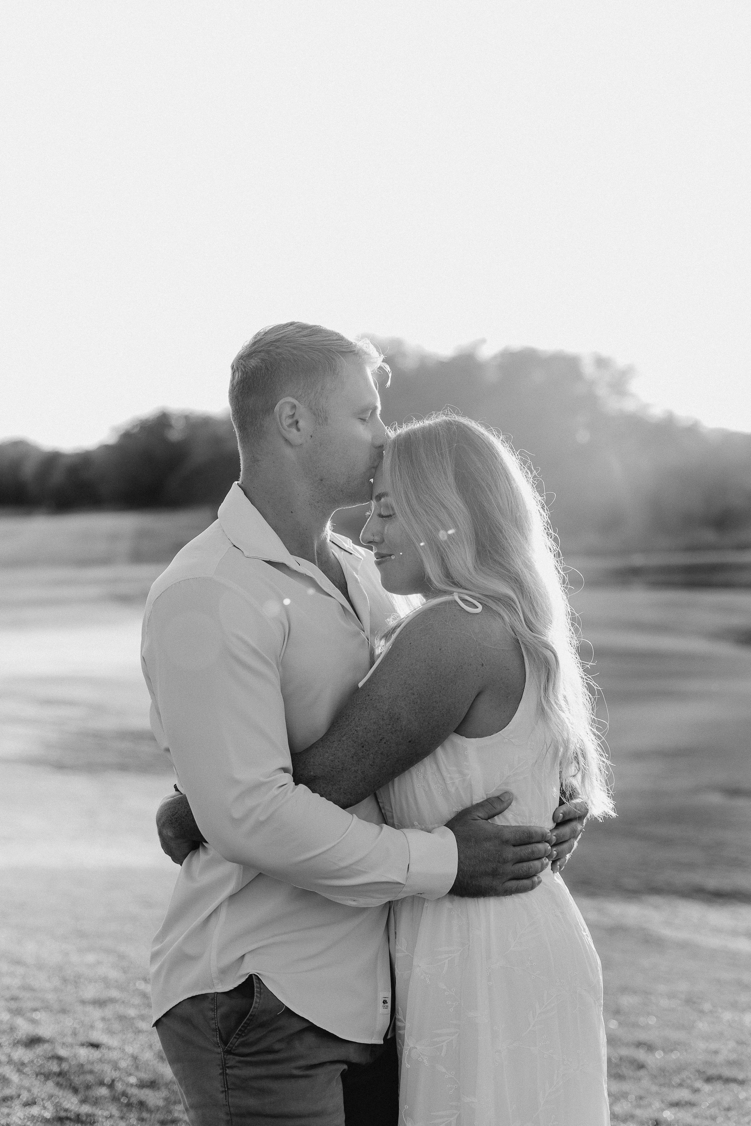 Romantic black and white sequence of a couple embracing in an open field at sunset.