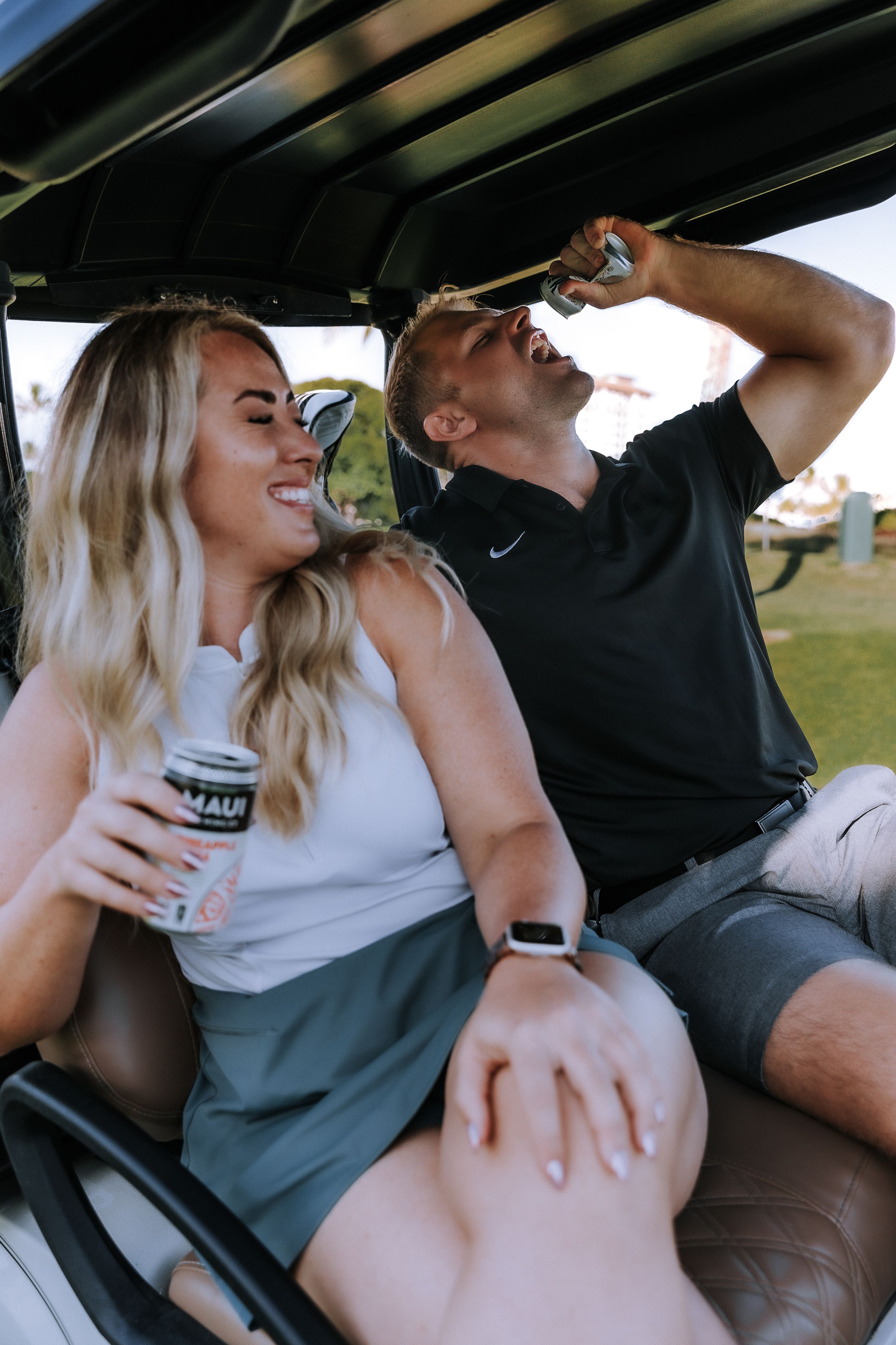 Couple enjoying a playful moment together in a golf cart.