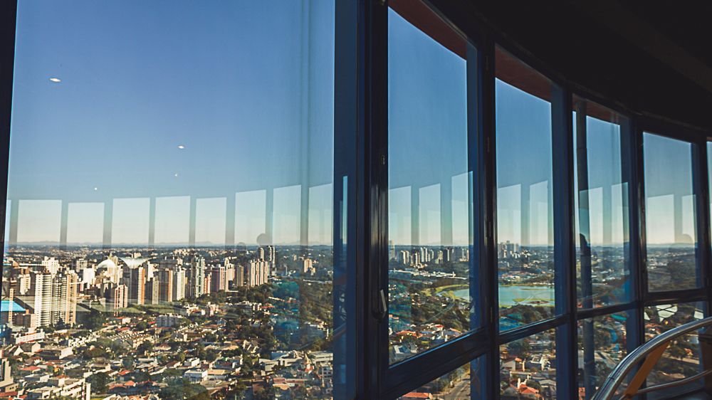 Curitiba city skyline reflected in glass windows, photographed by Piret Victoria Ribas.