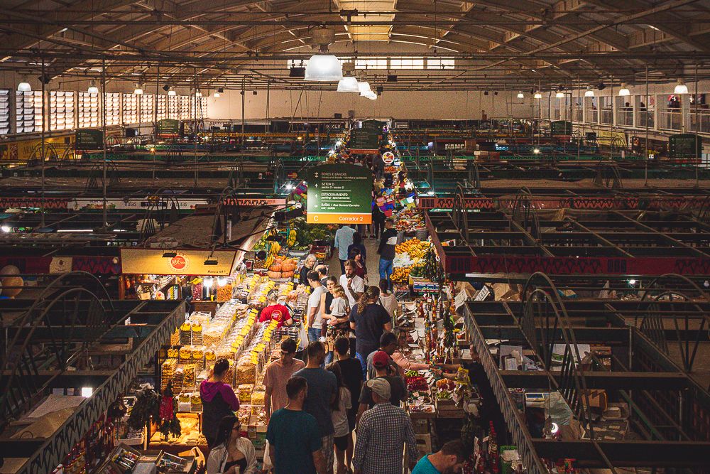 Top-down view of busy indoor market with colorful stalls, photographed by Piret Victoria Ribas.
