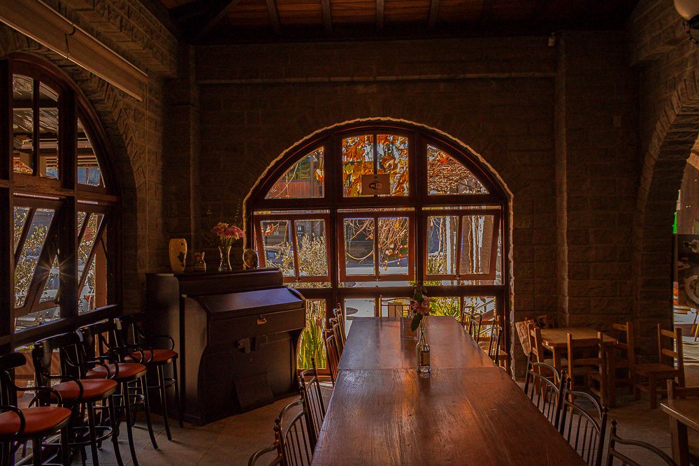 Elegant restaurant interior with grand piano and arched window, photographed by Piret Victoria Ribas.