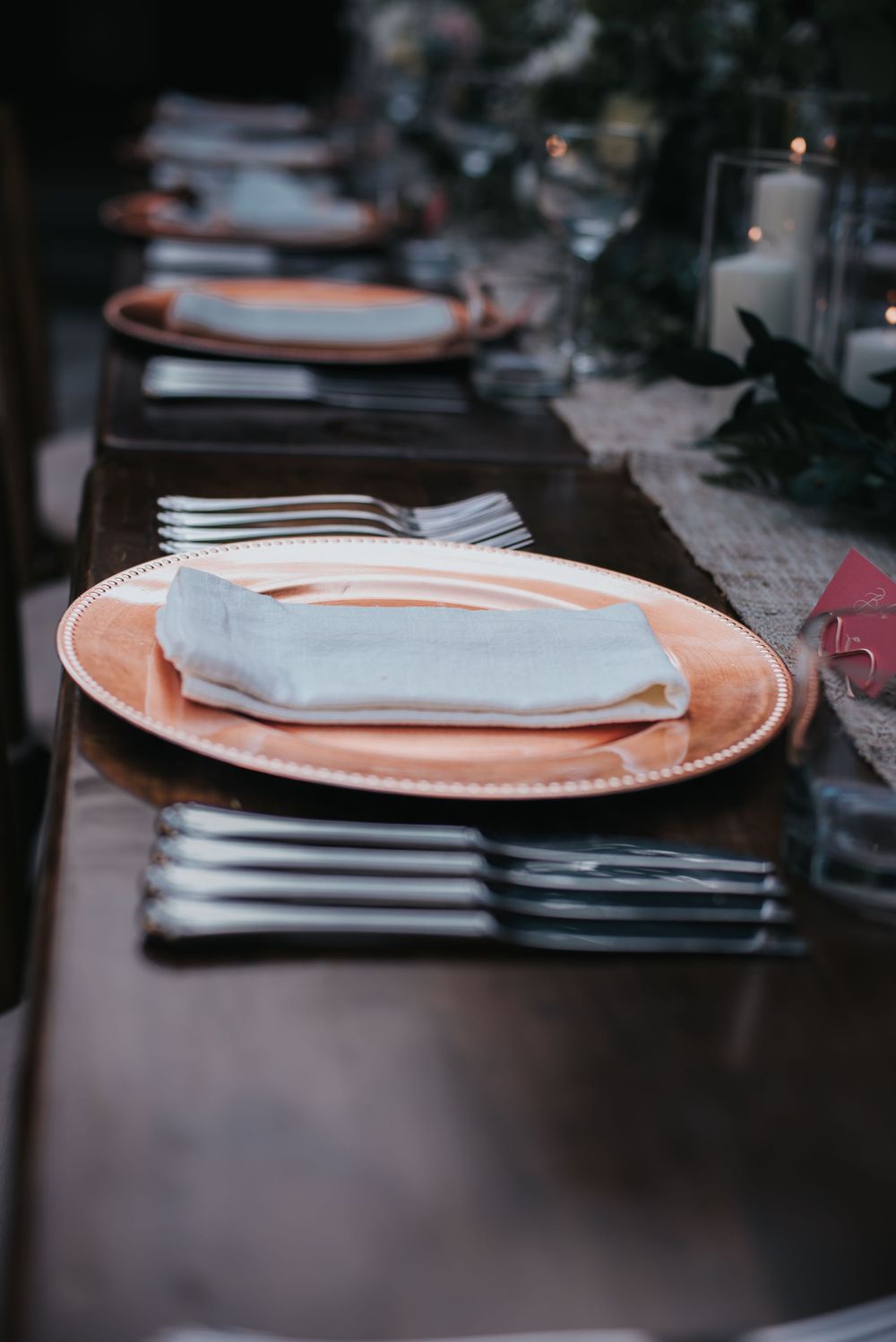 Brass table wear set on a long table for an intimate wedding.
