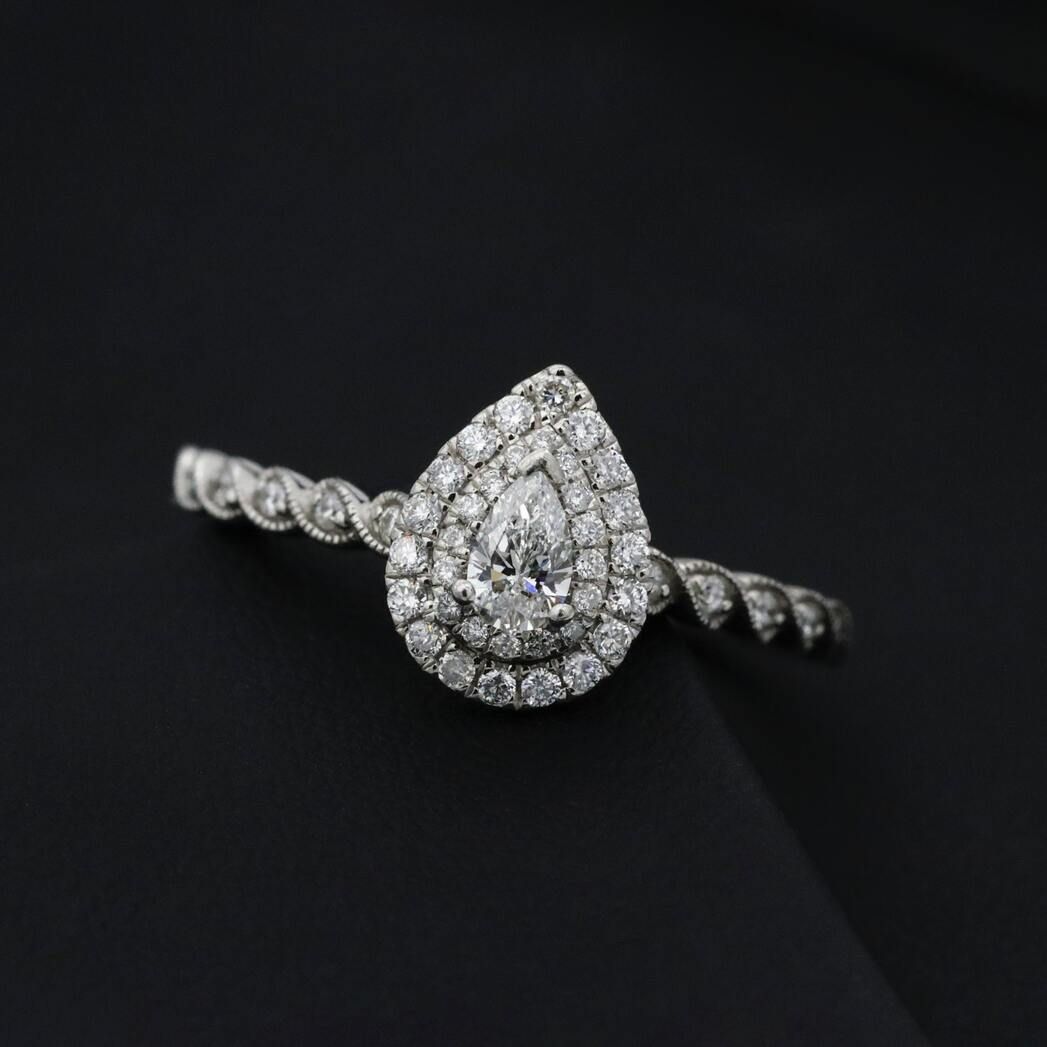 Pear cut diamond with two halos on dark background