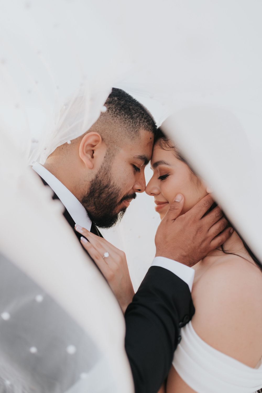 A couple embraces under a veil during their destination elopement to the Utah Salt Flats