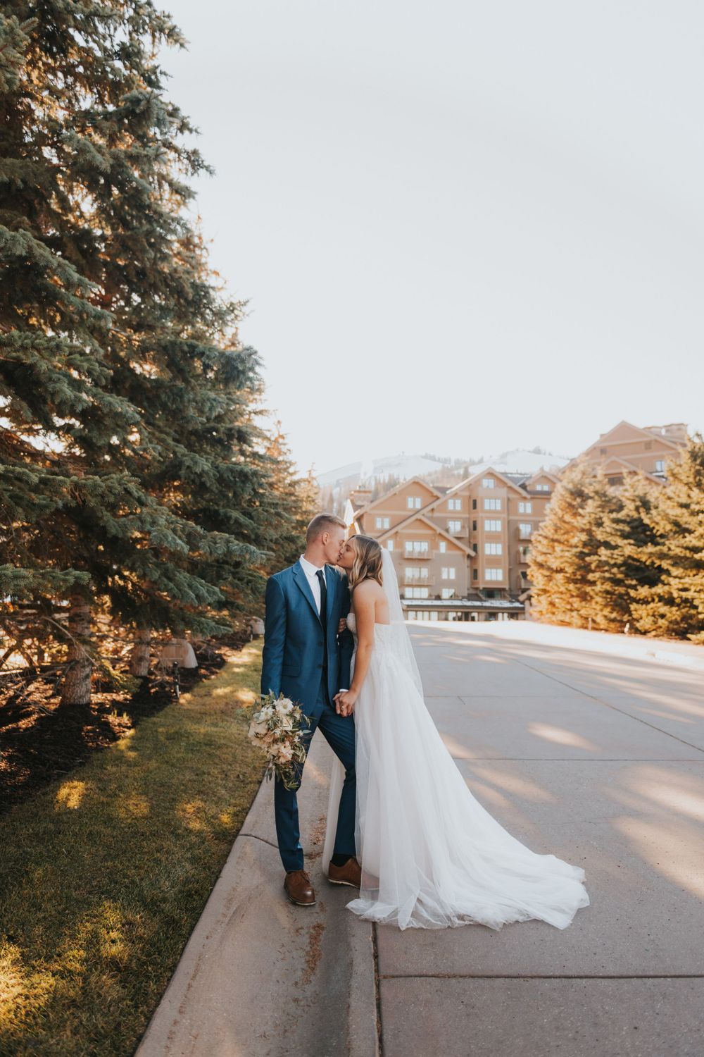 A couple kisses outside of St Regis Deer Valley during their intimate winter elopement in Park City Utah.