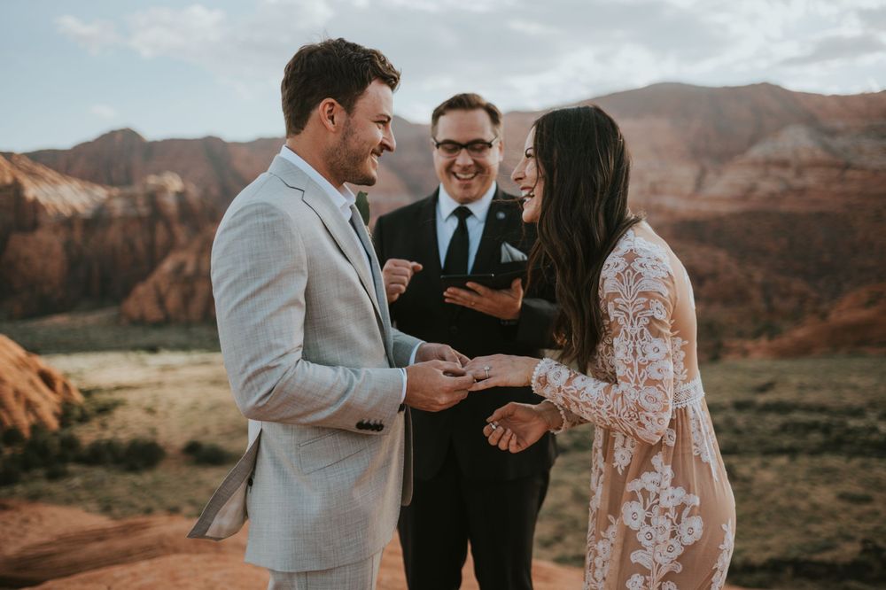 A couple smiles as they exchange rings during their destination elopement at Snow Canyon in St. George Utah.
