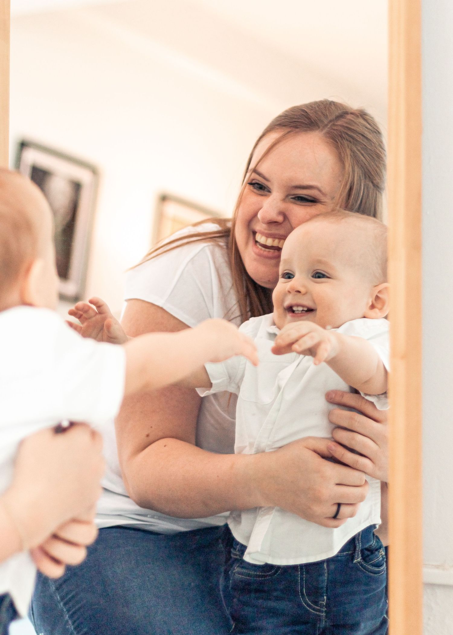 Mother and son holding each other and smiling into a mirror
