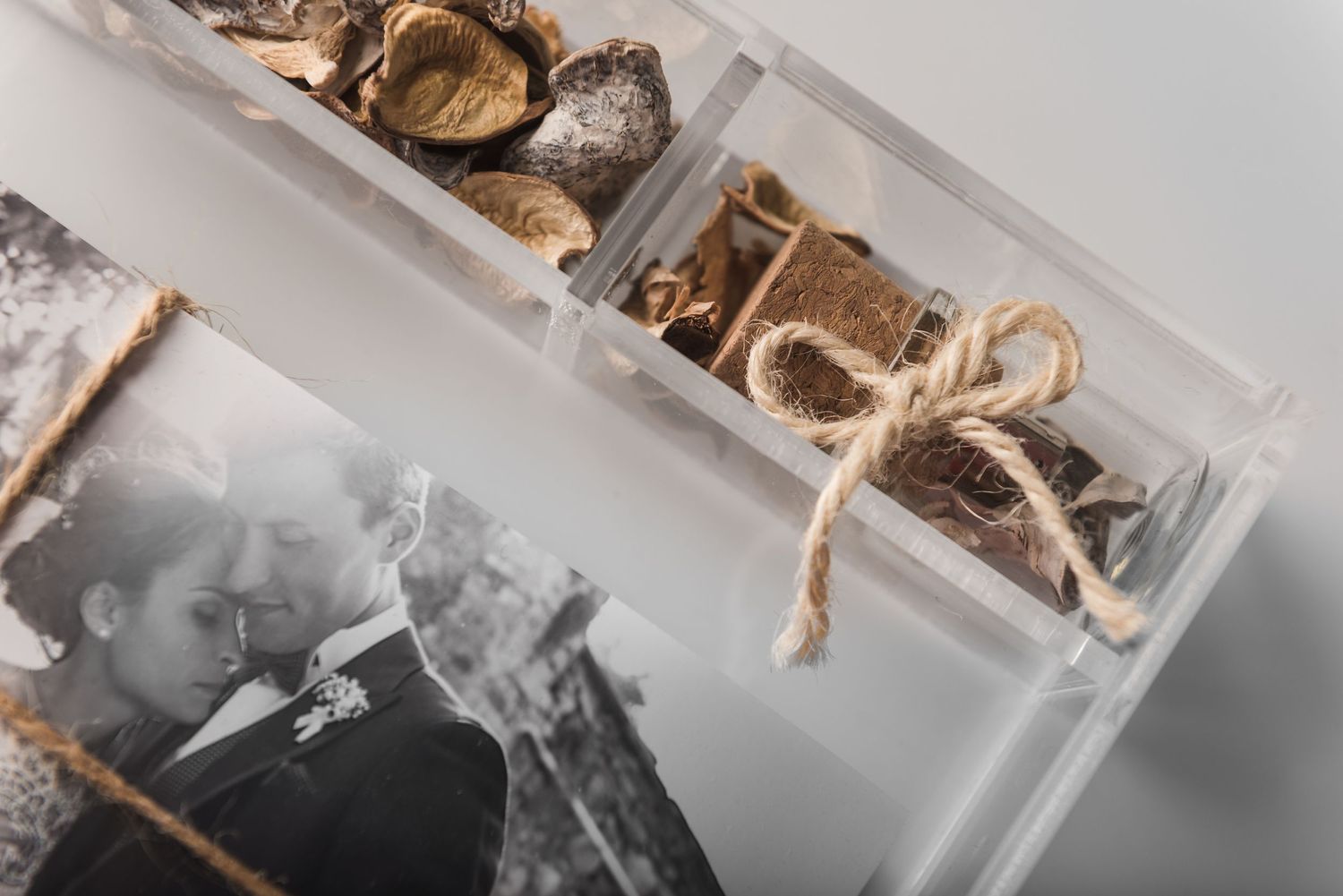 Close-up view of photographs and cork decorations in a clear display box.