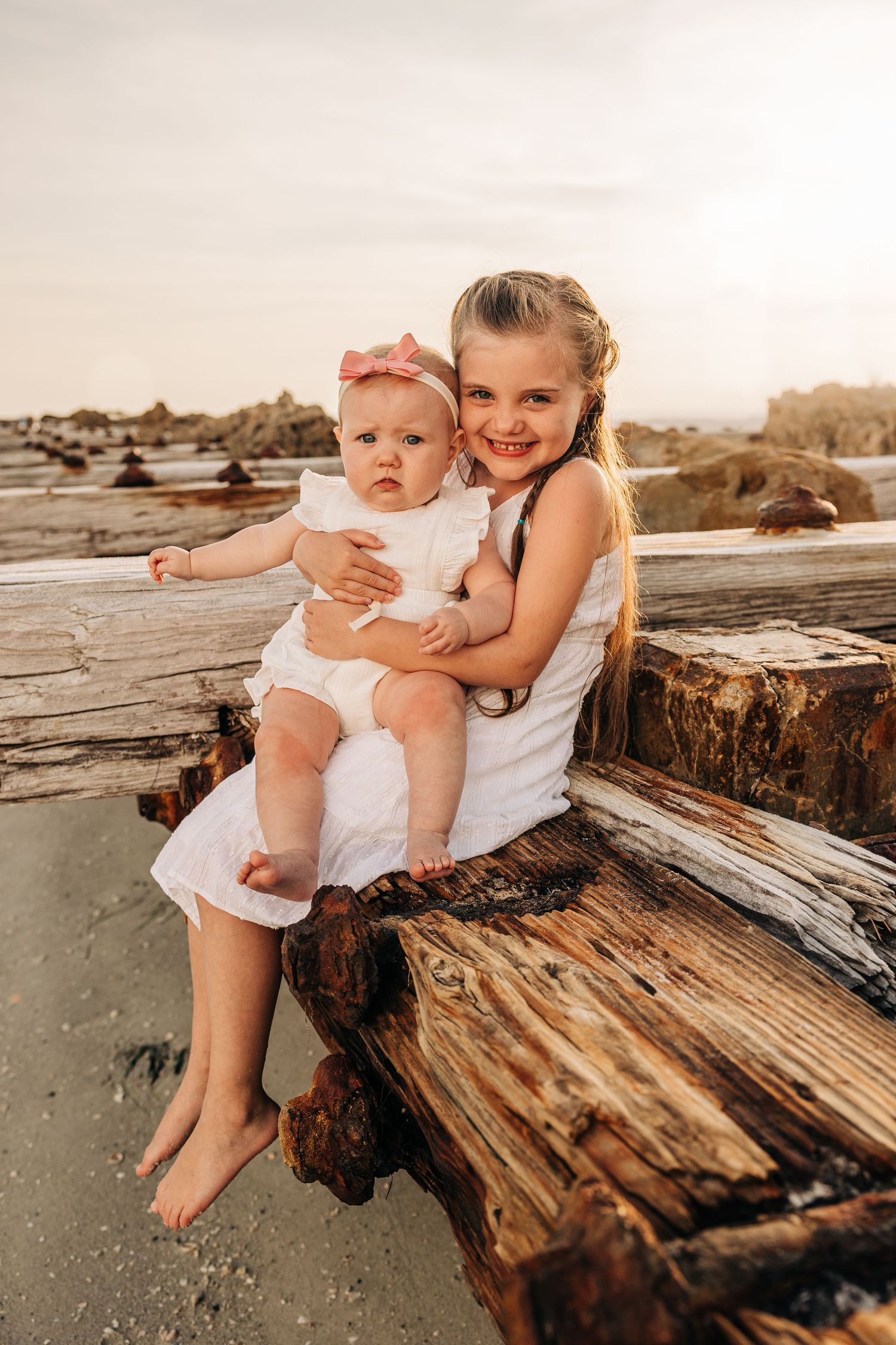 Baby girls smiling for the camera at Coquina Beach at sunset taken by Sarasota Family Photographer.