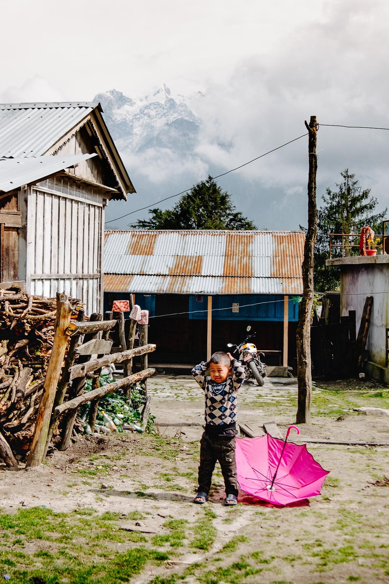 A sequence of photos showing someone opening a bright pink umbrella in a rustic outdoor setting with mountain views.