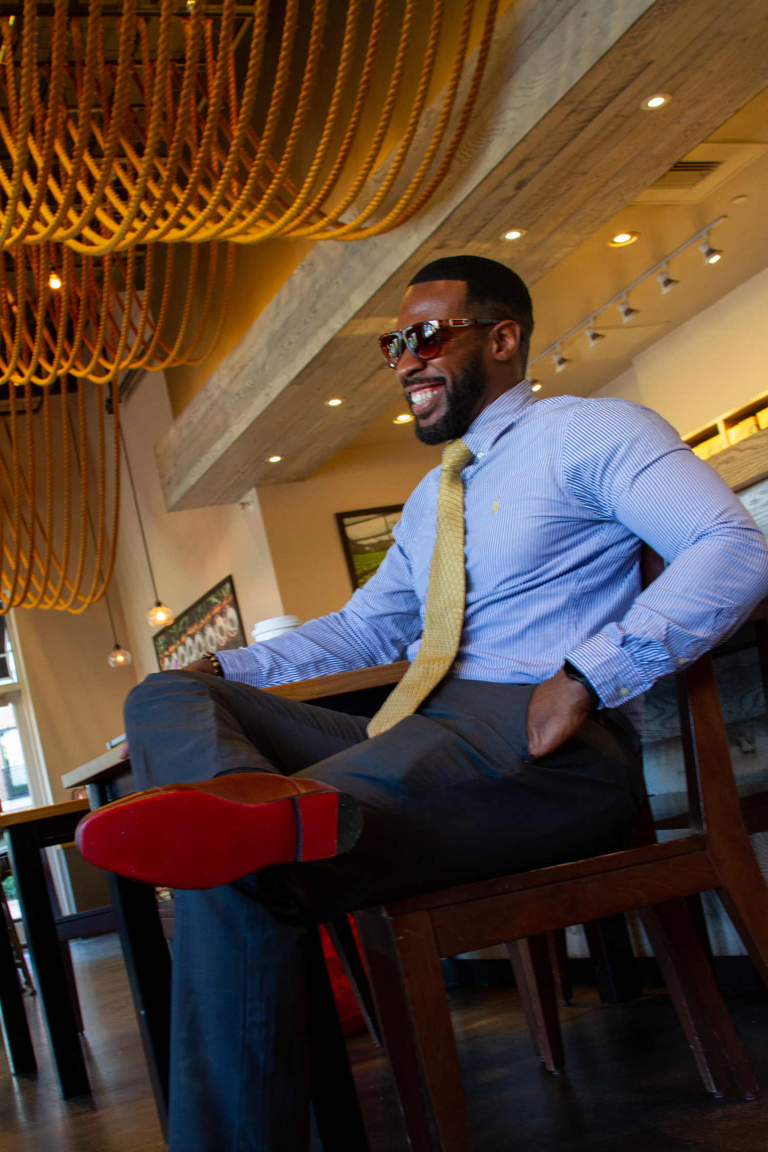 Professional in business attire working on phone in modern restaurant setting.  L Visions Photography. branding photoshoot. lifestyle photo