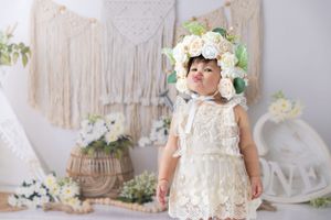 Bohemian styled photoshoot with macrame backdrop, white flowers and lace dress details.