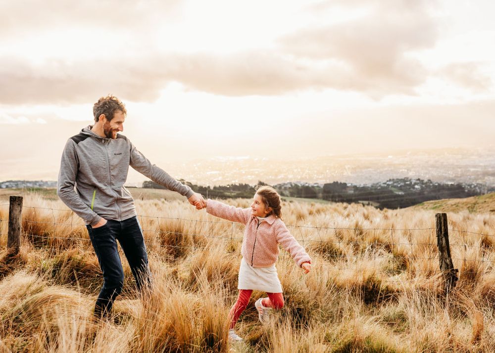 Joyful outdoor playtime between two people in golden grass field.
