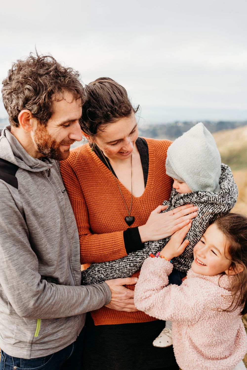 Candid family moment filled with laughter against scenic natural backdrop.