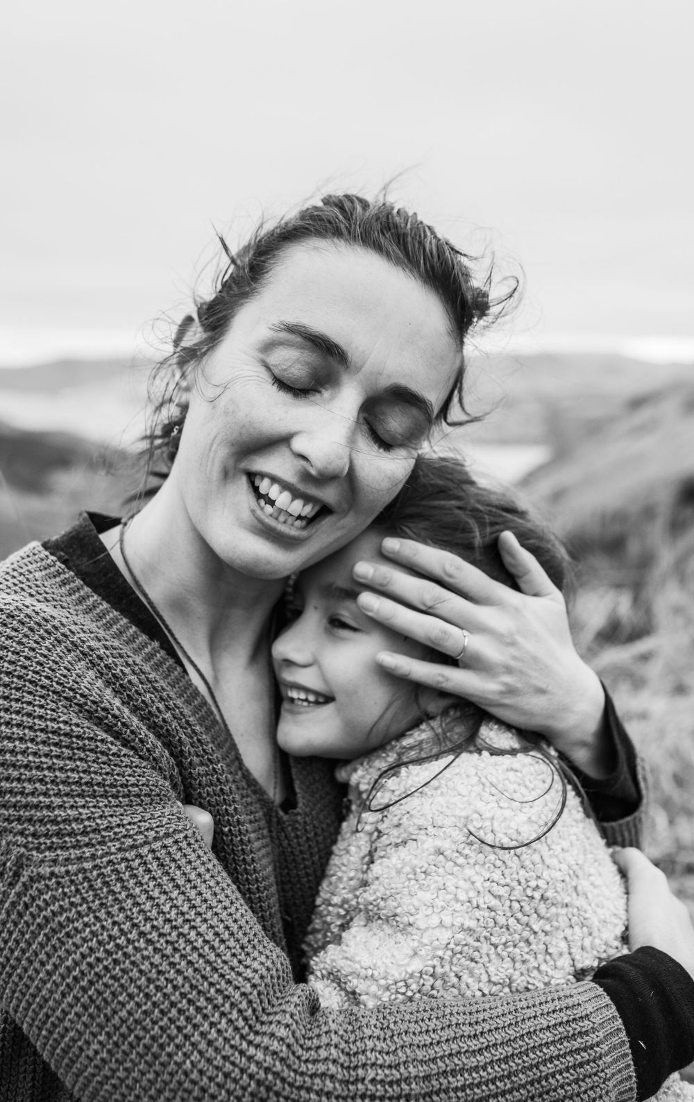 Black and white portrait capturing emotional embrace and joyful connection outdoors.