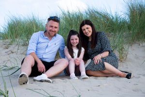 family sitting on the sand