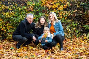 family playing in the autumn leaves.
