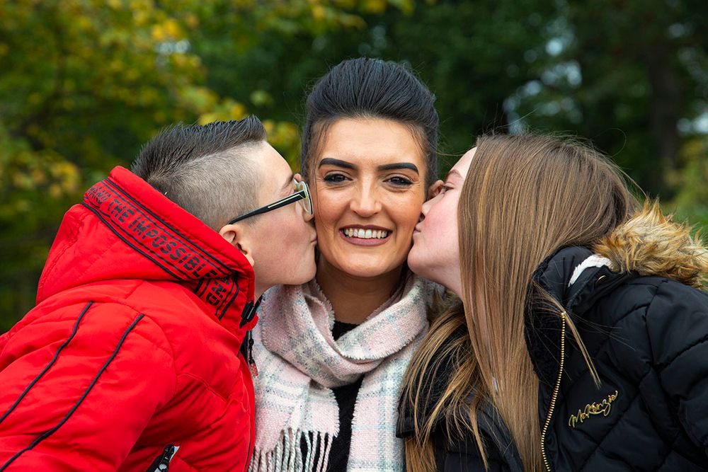 daughter and son kissing mum on the cheek