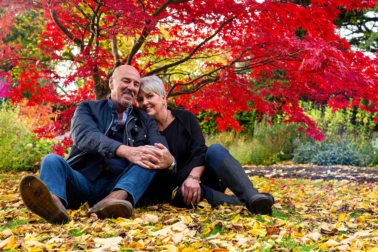 couple sitting in the autumn leaves