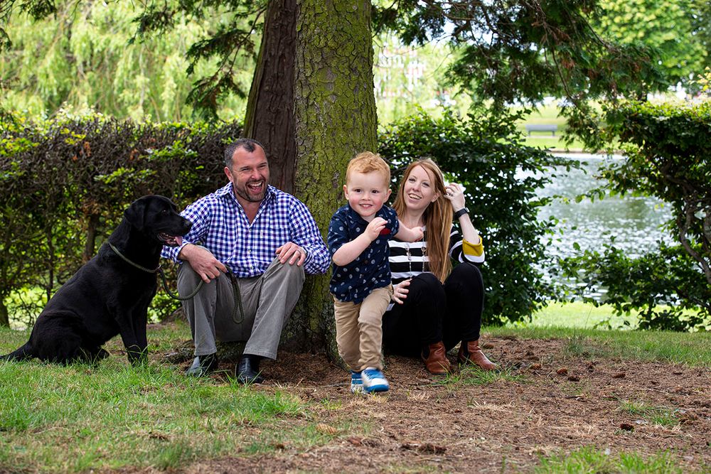 family and dog sitting under a tree.