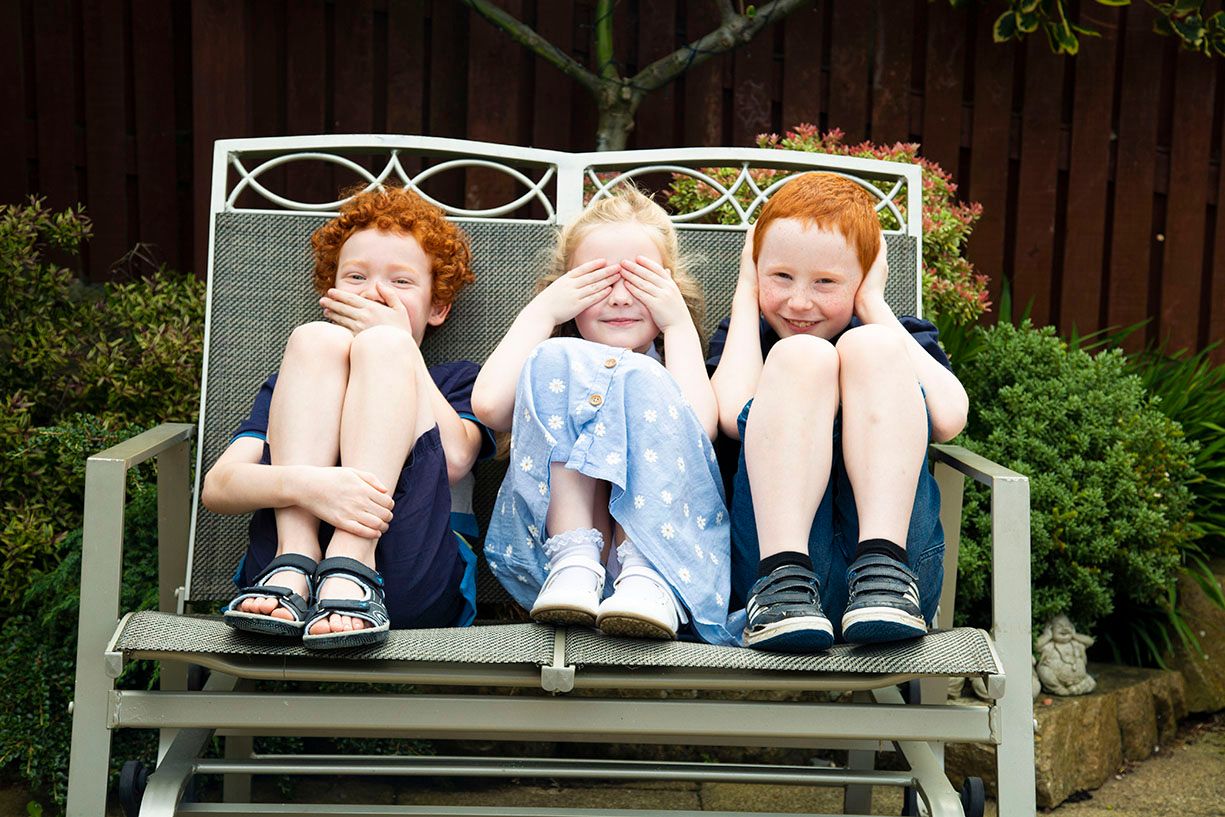 the children sitting on a metal bench