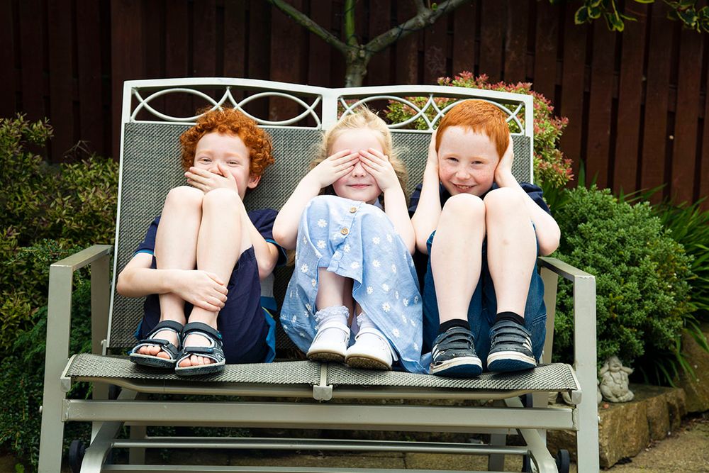 the children sitting on a metal bench