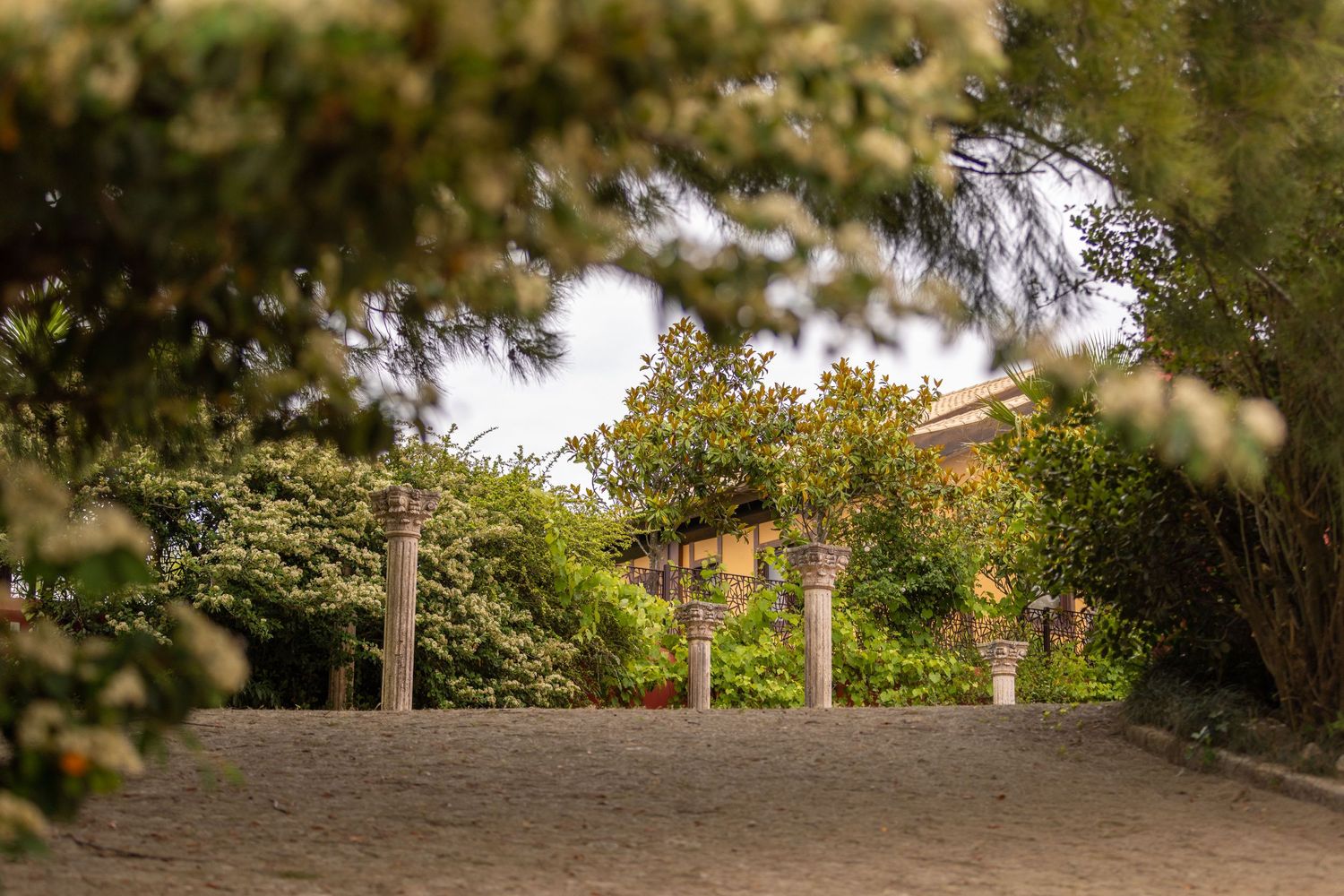 Stone pillars stand in a peaceful garden setting framed by lush greenery and natural landscaping.