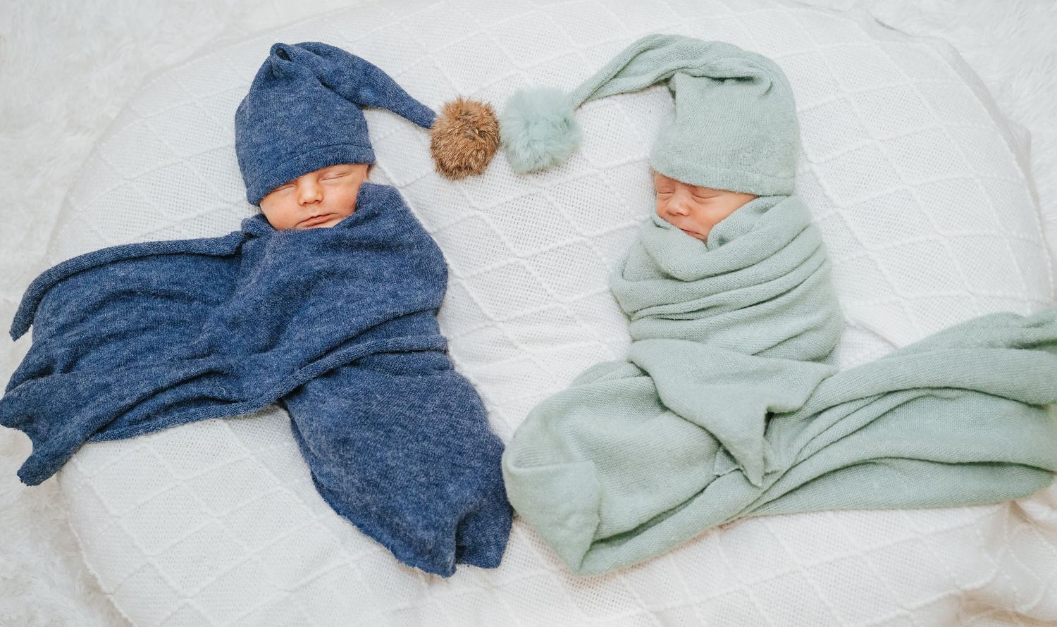 Twin newborn baby boys in a heart shape in Jacksonville, Florida