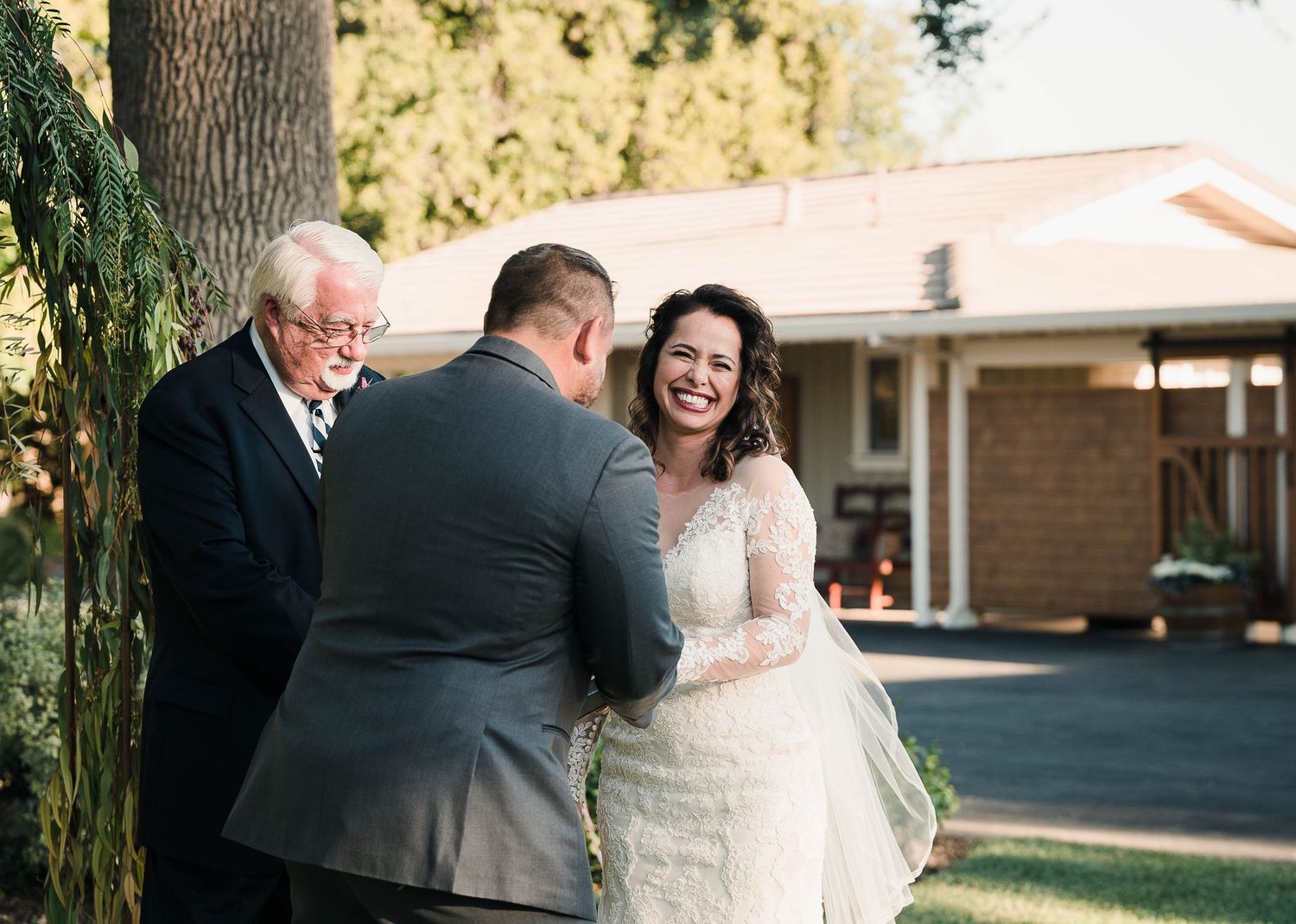 A heartfelt wedding ceremony moment taking place outdoors near a brick building.