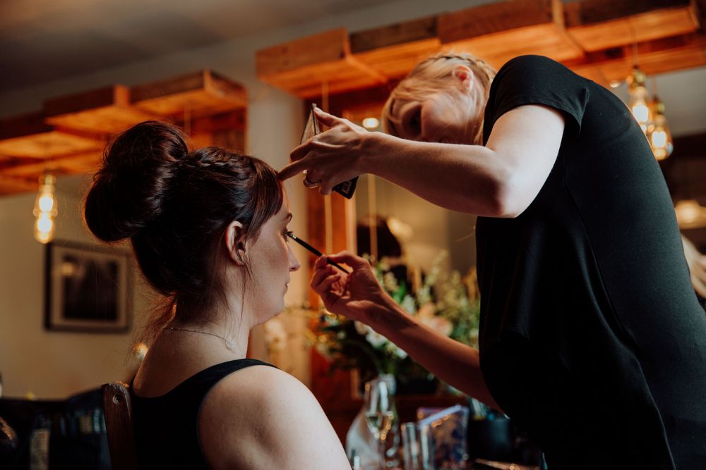 Getting ready moment captured during wedding preparations in warm indoor lighting.