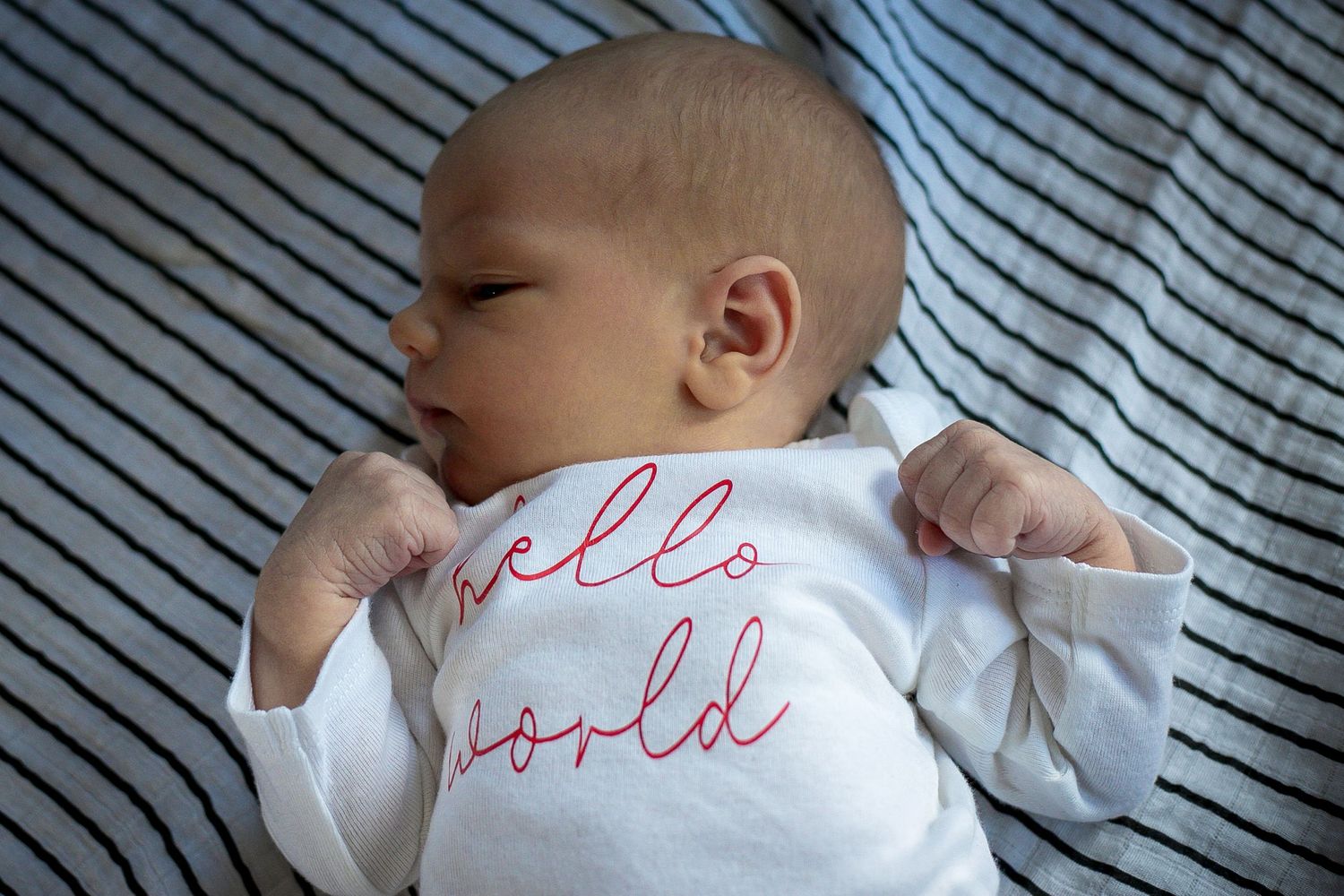 Newborn baby boy flexing his muscles during his in-home newborn session in Sioux City, IA.