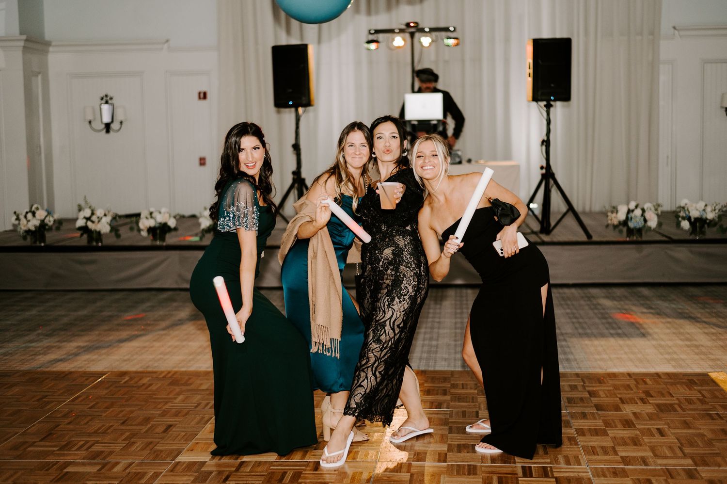 Wedding reception dance floor with guests celebrating under elegant lighting.