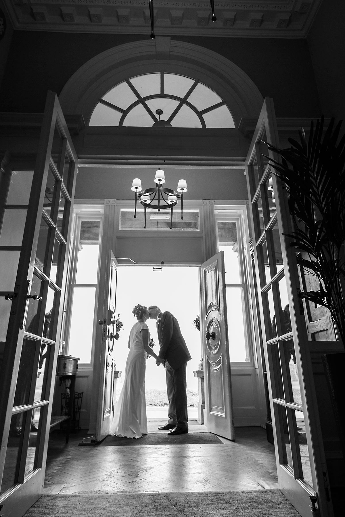 bride and groom kissing in the doorway at hothorpe hall leicestershire