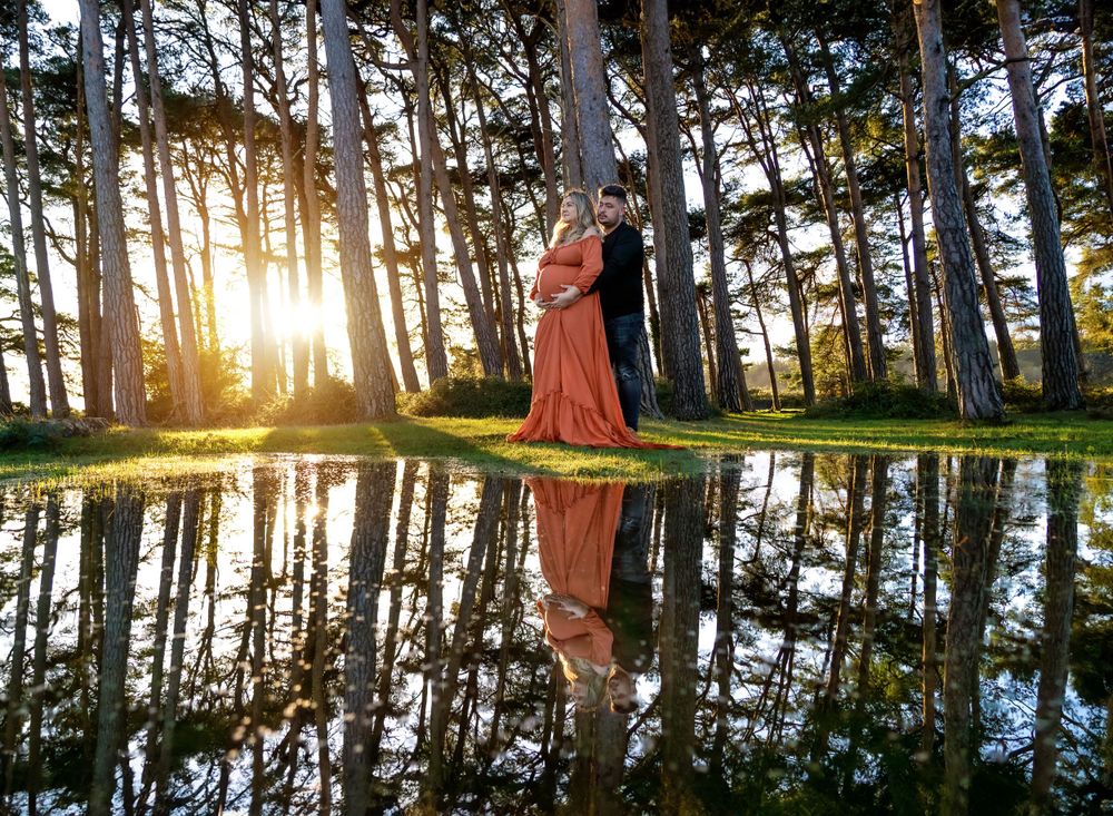 Maternity photo session at Hatchet Pond, New Forest, with trees reflecting in the water.