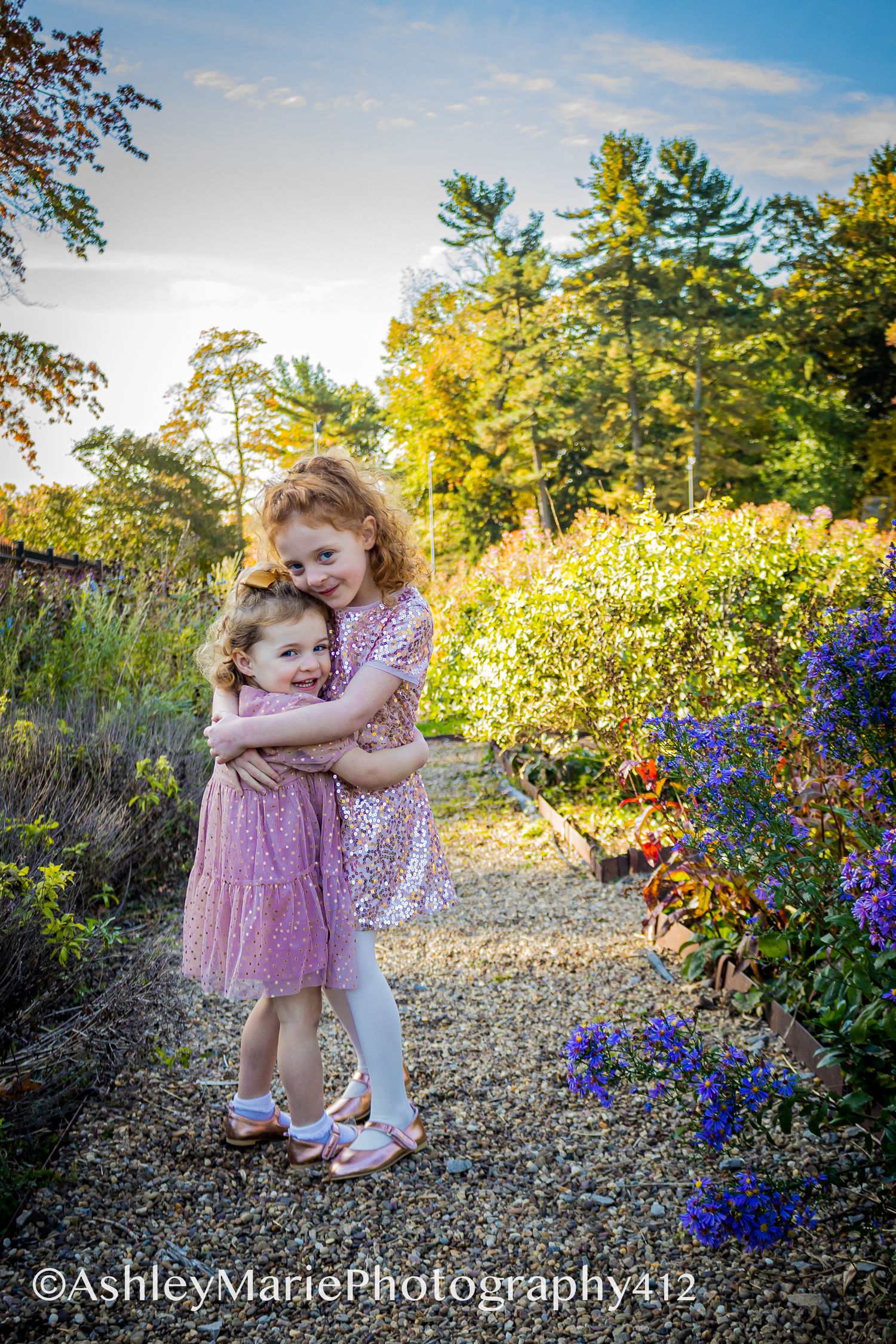 Adorable sisters in bright, colorful dresses share a heart melting moment