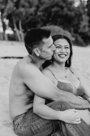 Black and white beach photoshoot capturing intimate family moments at sunset.